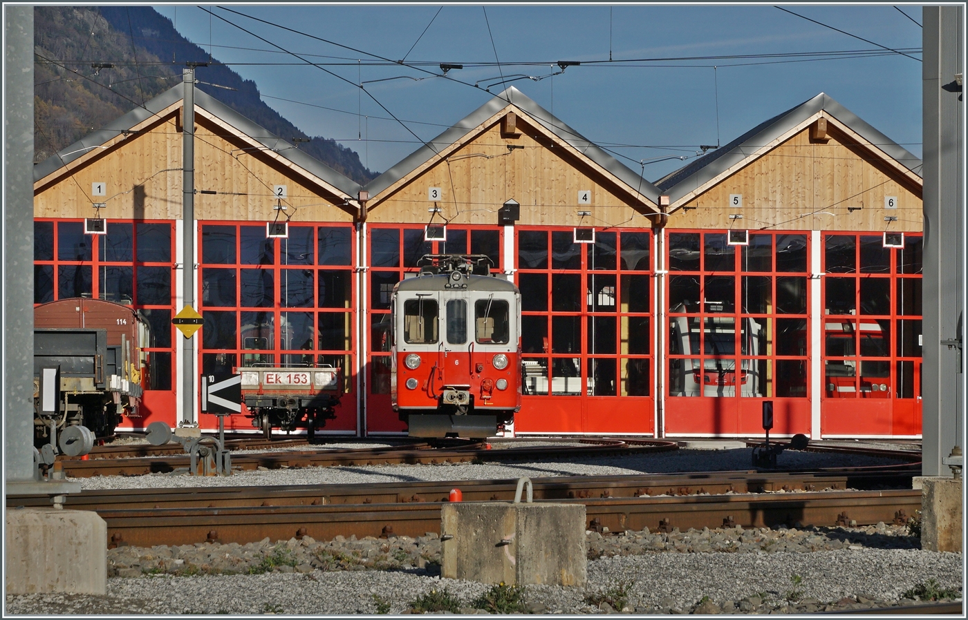 Ein Blick von der Zugangsstrasse über die Geleise auf das MC Dépôt in Vernayaz MC mit dem Xeh 4/4 N° 6 im Vordergrund. Und wer genau hinschaut entdeckt hinter den Schieben der geschlossen Tore allerlei interessantes. Doch zu meiner Enttäuschung stand nicht, wie letzte Woche kurz gesehen, einer der neuen Beh 4/8 VOR dem Dépôt. 

19. November 2025