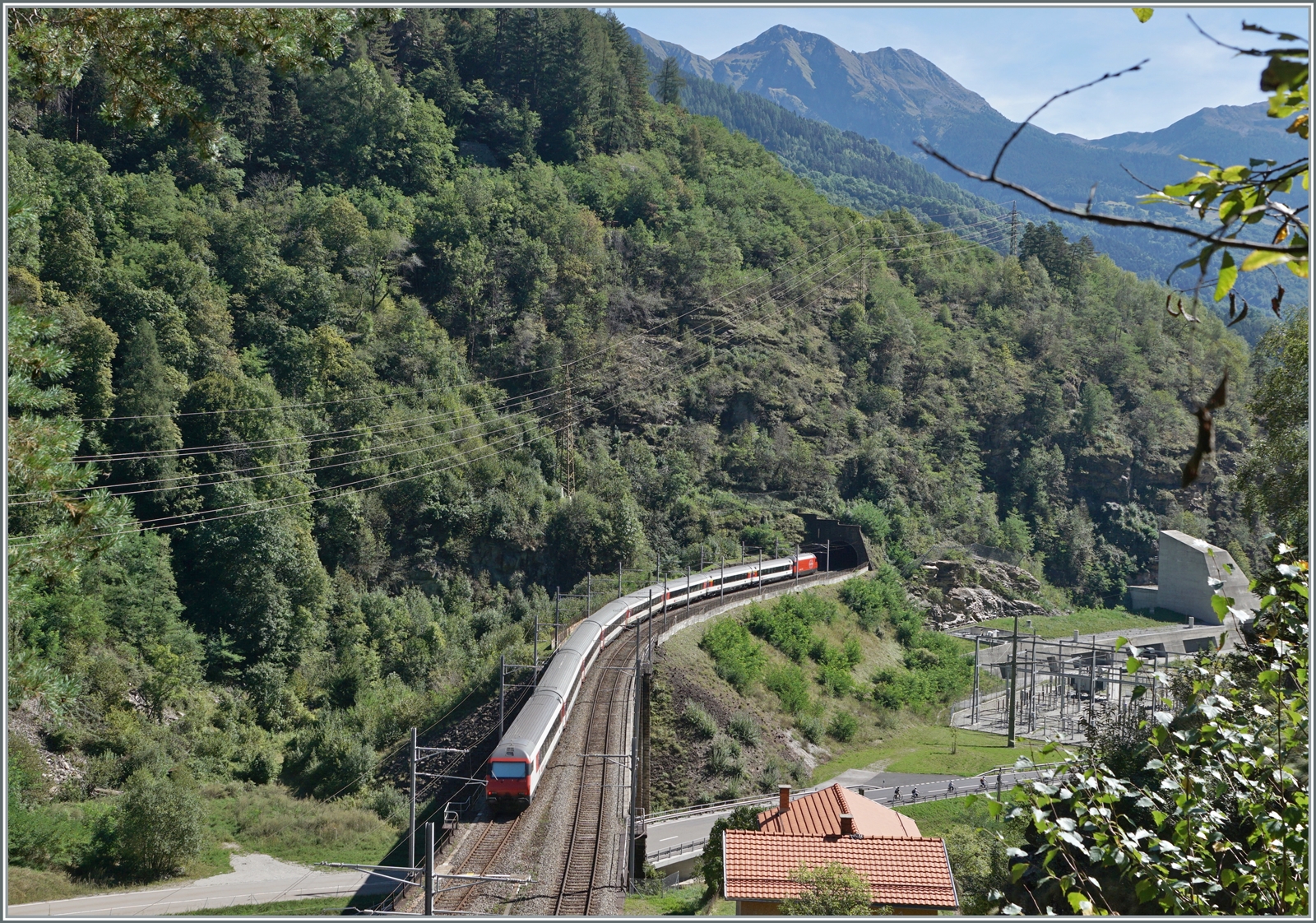 Ein SBB IC 2 nach Lugano auf der103 Meter langen Polmengobrücke über den  Tessin . Ganz rechts im Bild der Eingang zur  Multifunktonsstation  Faido  des GBT. 

4. Sept. 2023