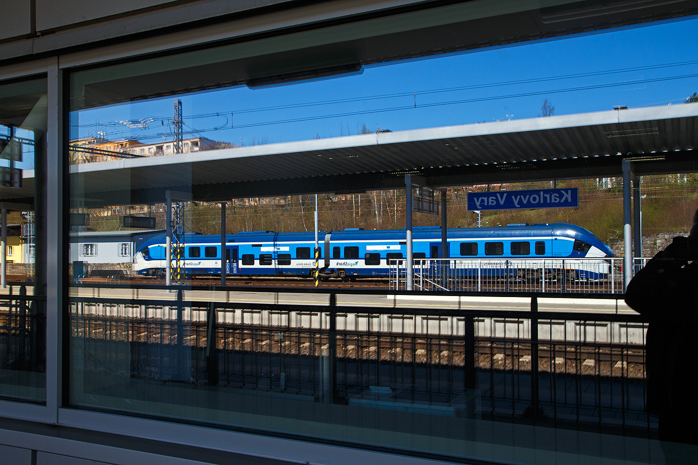 Eine kleine Spiegellei mit dem abgestellten ČD „RegioShark“  844 024-0 (CZ-ČD 95 54 5 844 024-0), ein Dieseltriebzug vom Typ PESA LINK II (Pesa 223M), am 19.04.2023 im Bahnhof Karlovy Vary (Horním nádražím) / Karlsbad (Oberer Bahnhof). 