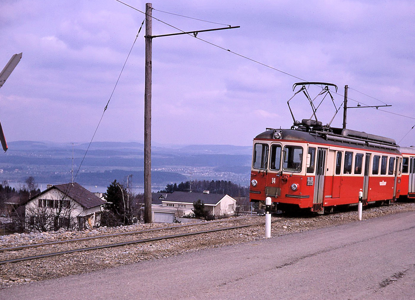 Forchbahn: Triebwagen 14 in der Steilrampe bei Scheuren mit Blick auf den Greifensee. 25.März 1970  