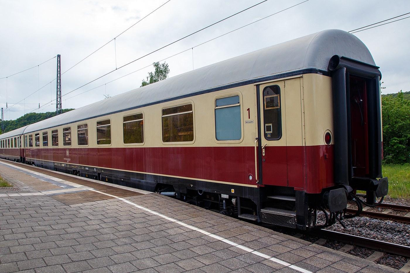 Klimatisierter 1. Klasse TEE Abteilwagen der Bauart Helvetia, D-DB 61 80 19-95 029-3 der Gattung Avmz 111.2, vom DB Museum Koblenz am 28.04.2018, im Zugverband von einen TEE Sonderzug (zum Dampfspektakel 2018) Koblenz – Trier, im Bahnhof Bullay DB.

Der Wagen wurde 1971 von Waggonfabrik Wegmann & Co. in Kassel gebaut und als D-DB 61 80 19-70 029-2 Avmz 111 an die Deutschen Bundesbahn geliefert. Ab 1977 wurde er zum 61 80 19-90 029-8 Avmz 111.1, und 1983 wurde er zum D-DB 61 80 19-95 029-3 Avmz 111.2.

Zum Jahresfahrplan 1965 wurden weitere F-Zge aufgewertet und in TEE-Zge umgewandelt (z. B. „Blauer Enzian“). Der TEE „Helvetia“ wurde von Triebzgen der Baureihe VT 11.5 auf einen lokbespannte Wagenzge umgestellt. Dafr mussten weitere Wagen angeschafft werden.
Bei den TEE -Wagen handelt es sich um eine Serie von Personenwagen der Deutschen Bundesbahn (DB) aus Erste-Klasse-Wagen, die aus den erfolgreichen UIC-X-Wagen der DB weiter entwickelt wurde.

Vorgesehen waren reine Erste-Klasse-Wagen in mehreren Bauarten. Die durch Gummiwlste geschtzten Wagenbergnge waren nach neuen UIC-Anforderungen aber nunmehr durch zweiflgelige Schiebetren gesichert. Jedoch waren die neuen Wagen klimatisiert. Der Bereich unterhalb des Wagenbodens wurde durch eine Schrze hnlich den Schrzenwagen geschtzt.

Bei den Drehgestellen kam wie bei den m-Wagen die Bauart Minden-Deutz zum Einsatz, die aber fr hhere Geschwindigkeiten ausgelegt wurden. Die Wagen sind mit selbstnachstellenden Scheibenbremsen und einer Magnetschienenbremse ausgerstet, so konnte die Hchstgeschwindigkeit auf 200 km/h erhht werden.

TECHNISCHE DATEN:
Lnge ber Puffer: 26.400 mm
Wagenkastenlnge: 26.100 mm
Wagenkastenbreite: 2.825 mm
Hhe ber Schienenoberkante: 4.050 mm
Drehzapfenabstand: 19.000 mm
Achsstand im Drehgestell: 2.500 mm
Drehgestellbauart: Minden-Deutz 367
Leergewicht: 44 t
Hchstgeschwindigkeit: 200 km/h
Sitzpltze (in der ersten Klasse): 54
Abteile: 9
Toiletten: 2
Heizungsbauart: Klimae
Energieversorgung: Zentrale Energieversorgung aus der Zugsammelschiene
Batterien: 24 V, 385 Ah
Bremsbauart: KE-GPR-Mg (D) [ep]
Zulassungen: D, A und CH (RIC)
Umgebaut aus: Avmz 111.1
