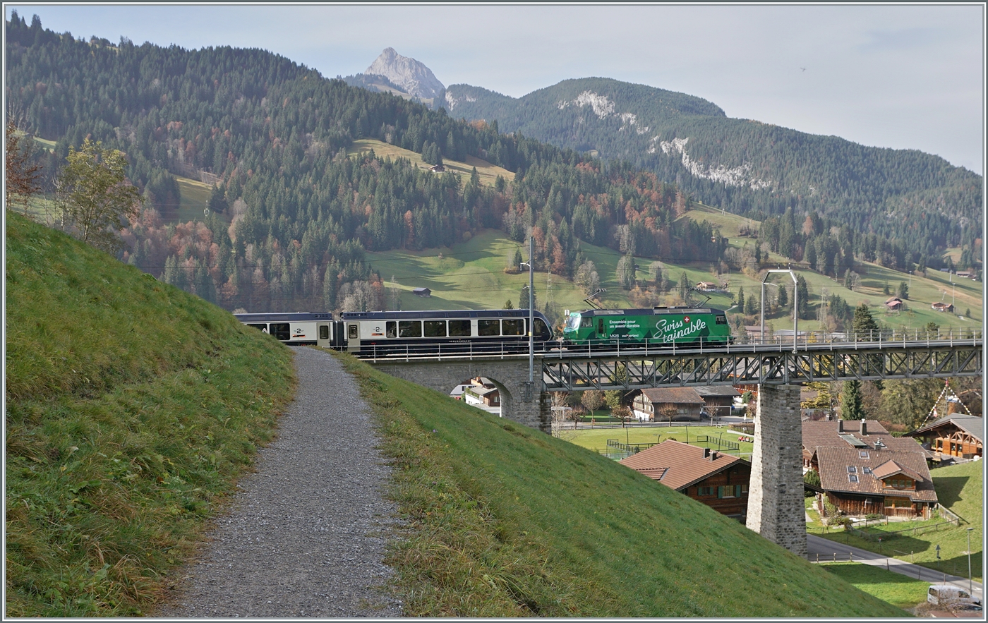Kurz nach Gstaad fährt die MOB Ge 4/4 8004  Swisstainable  mit ihrem GoldenPass Express auf der Fahrt von Interlaken nach Montreux über den Grubenbach Viadukt.

13. Oktober 2024