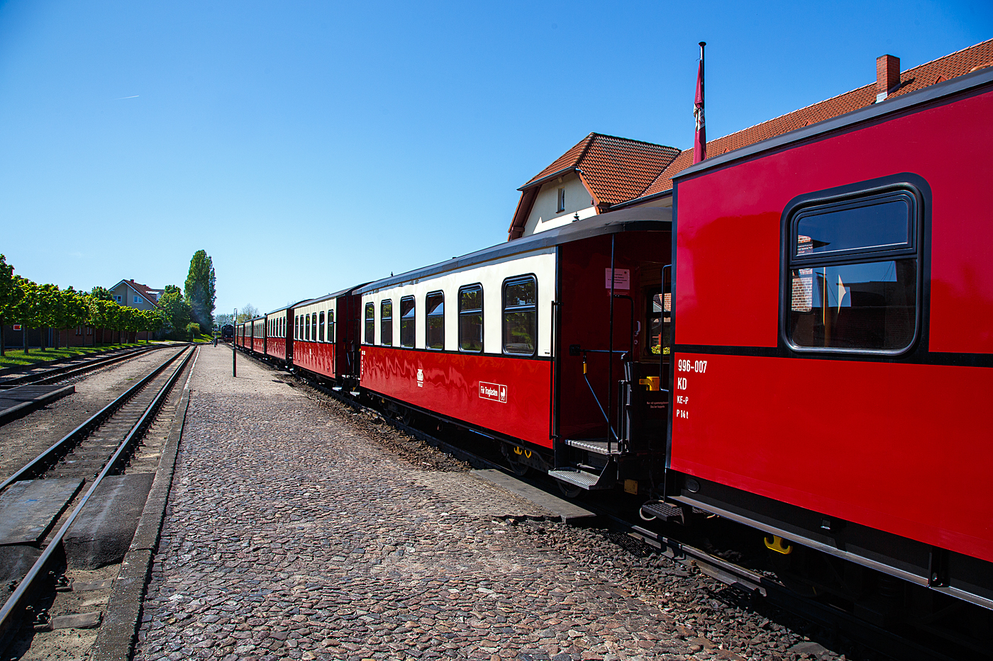 Schmalspuriger (900 mm) vierachsige 2.Klasse Personenwagen mit Traglastenabteil, offenen Plattformen und Holzdach, MBB 990-303 (ex DR 990-303), der Gattung KB4i, Mecklenburgische Bderbahn Molli GmbH & Co. (Molli), hier am 15 Mai 2022 im Bahnhof Khlungsborn-West im Zugverband.

Der Wagen wurde 1925 von der Waggonfabrik Wismar fr die Deutsche Reichsbahn Gesellschaft (DRG) gebaut und ist seitdem bei der Mecklenburgische Bderbahn im Einsatz, bereits 1938 wurde er einseitig als Traglastenwagen (fr Kinderwagen etc.) hergerichtet. Im Februar 1981 wurde er rekonstruiert. Im Fuhrpark des Molli befinden sich insgesamt 19 Personenwagen.

TECHNISCHE DATEN:
Spurweite: 900 mm
Anzahl der Achsen: 4
Lnge ber Puffer: 12.000 mm
Drehzapfenabstand: 6.500 mm
Eigengewicht: 15 t
Sitzpltze: 29 (in der 2. Klasse)
Bremse: KE-P 