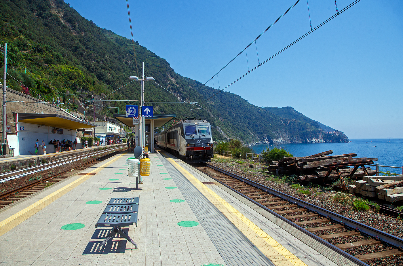 Trenitalia E.401.006 (91 83 2401 006-x I-TI), ex FS E.402.006 (E.402A) rauscht am 21.07.2022 mit einem Intercity (IC) durch den Cinque Terre Bahnhof Corniglia in Richtung Levanto bzw. Genua (Genova). 

Corniglia hat zwar diesen Bahnhof an der Bahnstrecke Pisa–Genua, aber Corniglia ist das einzige Dorf der Cinque Terre (5 Drfer) das nicht direkt am Meer, sondern auf einem Bergvorsprung in etwa 100 m Hhe, umgeben von drei groen Weinbergflchen und einer steilen Klippe zum Meer. So msste man hier vom viel tiefer gelegenen Bahnhof aus ber die Lardarina, eine lange Ziegelsteintreppe, laufen. 

Wer wie wir die Cinque Terre Card Treno (Zugkarte) hat, knnte sich aber auch mit den Minibusen des Cinque Terre Parks (im Preis der Cinque Terre Treno Card eingeschlossen) die ber 1 km lange Strecke hinauf fahren lassen. Aber die Busse waren uns einfach zu voll. Mit der Karte hat man auch Zutritt zu den beiden gebhrenpflichtigen Wanderwegen des Cinque Terre Parks.


Rechts auf den Felsvorsprung kann man Manarola erkennen.


