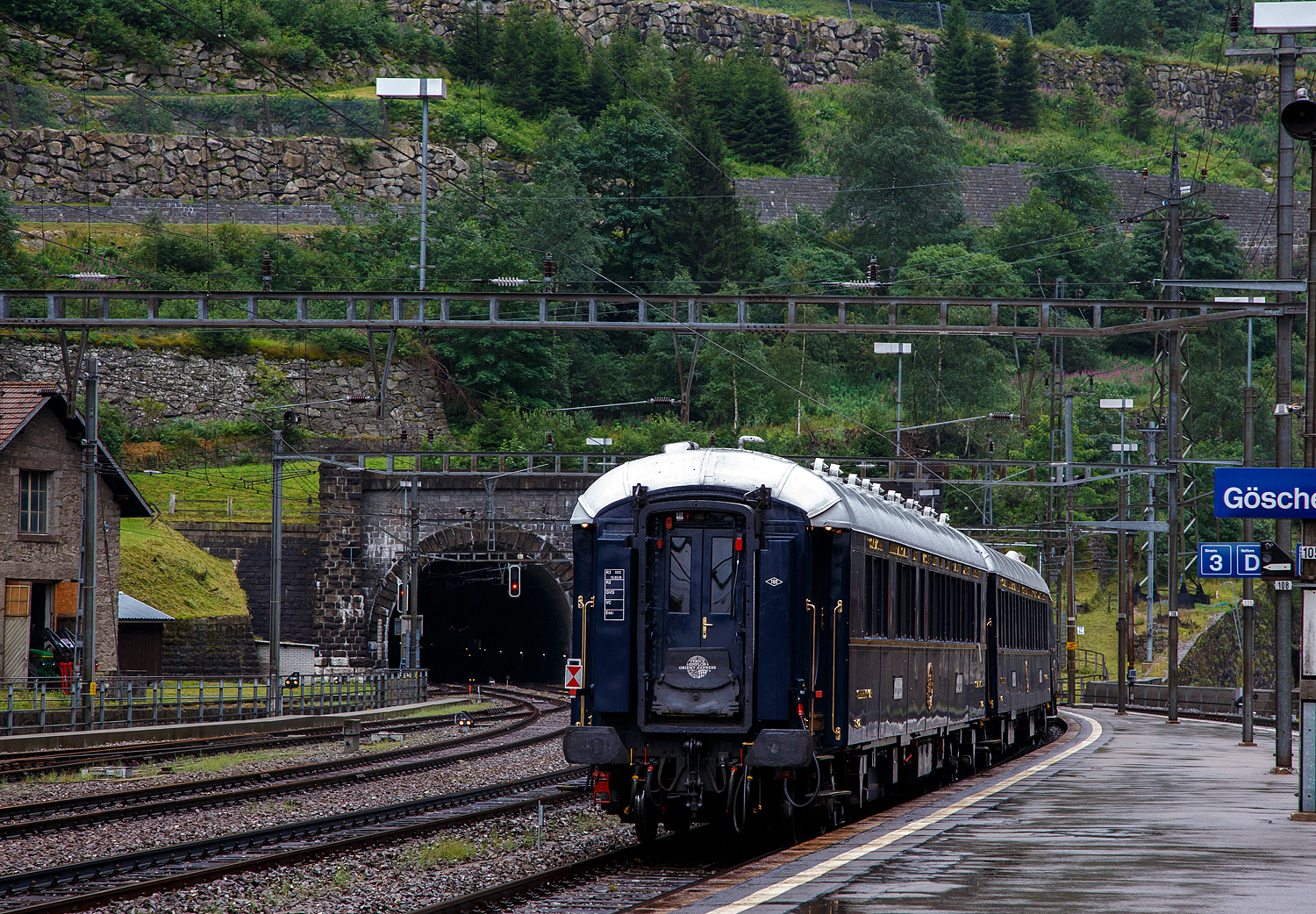 Und tschüs, nun fährt der VSOE - Venice Simplon-Orient-Express von Amsterdam über Brüssel und Paris nach Venedig, am 02.08.2019, vom Bahnhof Göschenen ins Nordportal des 15 km langen Gotthard-Scheiteltunnel ein und weiter in Richtung Chiasso. Bevor es weiter nach Italien und dem Ziel Venedig geht, werden in Chiasso die Loks gewechselt, die Vorräte aufgefüllt und Schmutzwasser abgelassen. 

Hier am Zugschluss der VSOE Schlafwagen Nr. 3425 – VSOE Sleeping-Car / Voiture-Lits / Carrozza-Letti N° 3425 (F- VSOE 61 87 76-70 425-5), einer der beiden  Grand Suite -Wagen (mit seinen drei Suiten „Paris, Istanbul und Venedig), ein ehemaliger CIWL Type S1-Wagen. 

Der Wagen wurde 1929 von der Birmingham Railway Carriage and Wagon Company (BRC&W) als gebaut und als Schlafwagen (WL) vom Typ S1 an die CIWL geliefert die ihn als Nr. 3425 bezeichnete. Die S1-Wagen hatten ursprünglich 17 Betten, 9 in Einzel- und 4 in Zweibett-Abteile. Ende der 1970er Jahre wurde der Wagen an die VSOE verkauft. Im März 2018 wurde bei der VSOE mit der Umrüstung des S1-Schlafwagens Nr. 3425 die Klasse Grand Suite eingeführt. Die drei Suiten (Paris, Istanbul und Venedig) verfügen über Doppel- oder Einzelbetten sowie einen Salon mit Sofa (das in ein drittes Bett umgewandelt werden kann) und ein eigenes Bad. Einfach purer Luxus. 

TECHNIK:
Der Wagenkasten bestand erstmals komplett aus Stahlprofilen und -blechen. Ebenso kam erstmalig ein standardisiertes Fahrgestell mit 23.452 mm Länge über Puffer und einem Drehzapfenabstand von 16.000 mm sowie neu konstruierte Schwanenhals-Drehgestelle mit Rollenlager zur Anwendung, welche für eine größere Laufruhe sorgten. Die Fahrzeugbreite betrug einheitlich 2.850 mm, die Höhe über Schienenoberkante wird mit 4.000 mm angegeben.

Auf diesem aus drei Längsträgern mit Querverbindungen und zwei Gussstahlblöcken zur Aufnahme der Zug- und Stoßvorrichtungen bestehenden Rahmen entstanden neben dem Typ S auch die Schlafwagen der Typen Lx, Y und Z sowie die ab 1922 beschafften Ganzstahl-Speisewagen und Pullmanwagen der CIWL.

Im Laufe der Jahre wurden die Drehgestelle modernisiert oder durch neuere Bauarten ersetzt. Ursprünglich waren die Waggons für 130 km/h zugelassen, nach dem Zweiten Weltkrieg konnte die Höchstgeschwindigkeit auf 140 km/h angehoben werden. Die mit neuen luftgeferderten Drehgestellen von Bombardier, zwischen 2003 bis 2006, ausgerüsteten Wagen des VSOE sind für maximal 160 km/h zugelassen.

Die Wagen waren standardmäßig mit einer Dampfheizung und einer davon unabhängigen Kohleheizung ausgestattet, welche durch den Schlafwagenschaffner bedient wurde. Der Heizkessel war an einem Wagenende stehend situiert und über die Plattform zugänglich. Später erhielten die Fahrzeuge zudem elektrische Heizungen.

Der Schlafwagenschaffner nächtigte auf einer an seinem Sitzplatz am Ende des Wagens befindlichen, aufklappbaren Liege im Gang. An beiden Wagenenden befanden sich Schränke für die zur Versorgung der Fahrgäste notwendigen Utensilien sowie jeweils ein WC.
