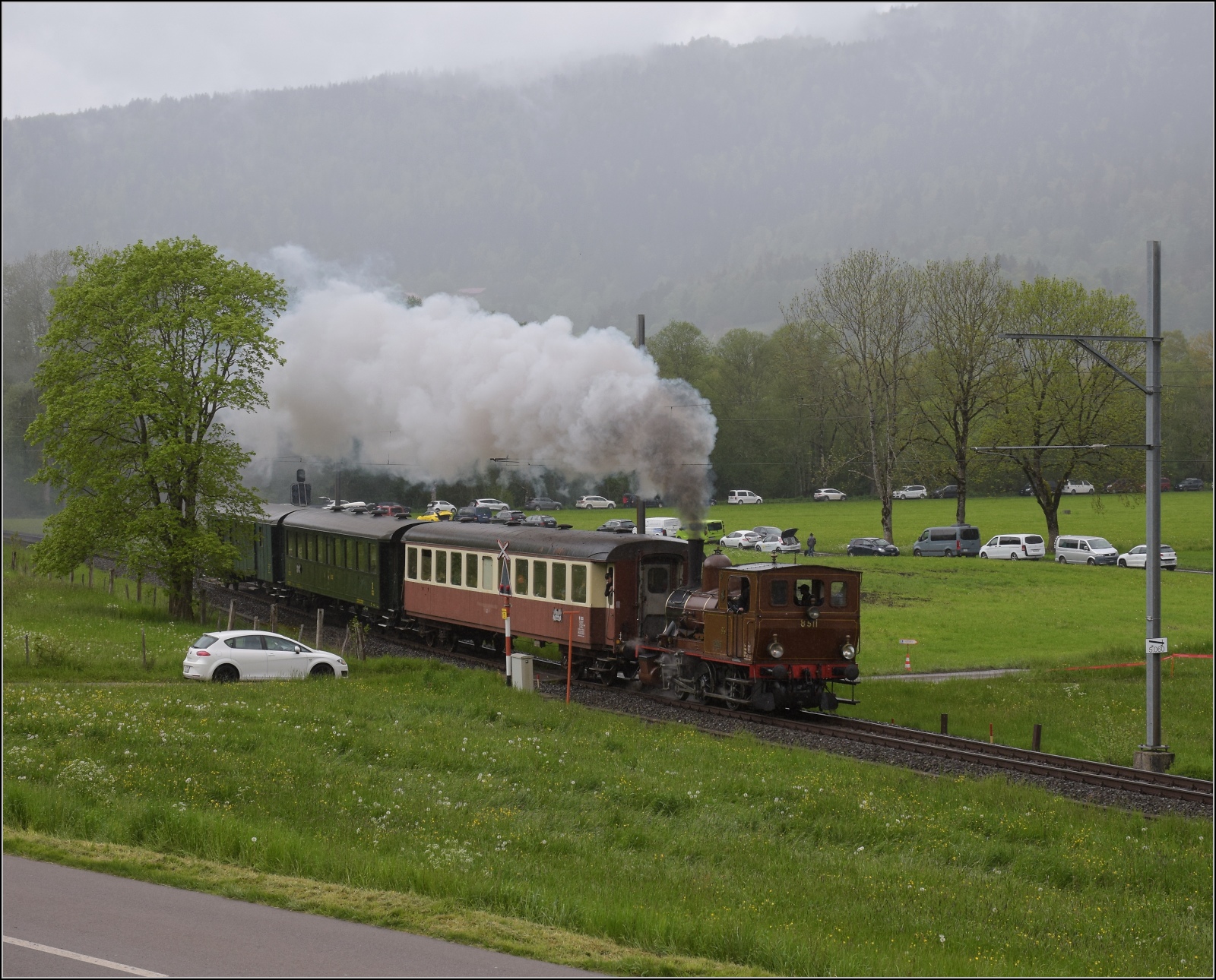 Vapeur Val-de-Travers: Train  Au fil de l'Areuse .

E 3/3 8511 umfährt das Landhaus Le Marais zwischen Môtiers und Couvet. Mai 2023.