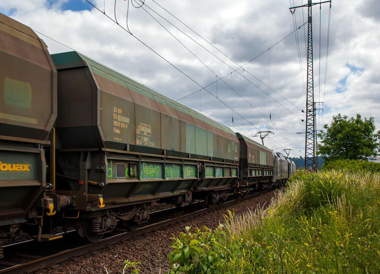 Vierachsiger 86m³ offener Schüttgutwagen (Kohlewagen) mit schlagartiger Schwerkraftentladung und pneumatischer Klappenbetätigung, 33 53 6635 001-5 RO-TOUAX, der Gattung Falns 86 m³, der irländischen Vermietungsfirma TOUAX Rail Limited (in Rumänien eingestellt), eingereiht im Zugverband (gezogen von zwei 182er) bei der Zugdurchfahrt am 18. Juni 2017 durch Koblenz-Lützel in Richtung Süden.

TECHNISCHE DATEN:
Länge über Puffer: 14.540 mm (Normalspur)
Anzahl der Achsen: 4 (in 2 Drehgestellen)
Länge über Puffer: 14.540 mm
Drehzapfenabstand: 9.000 mm
Achsabstand im Drehgestell: 1.800 mm
Laufraddurchmesser: 920 mm (neu)
Max. Eigengewicht: 26.400 kg
Ladevolumen: 86 m³
Max. Ladegewicht: 63,6 t ab Streckenklasse D
Höchstgeschwindigkeit: 100 km/h (beladen) / 120 km/h (leer)
Beladung Öffnung: 12.800 mm x 1.957 mm
Entladung Öffnungen je Längsseite: 2 x 5.700 mm, je 610 mm hoch
Entladung per Schwerkraft, beidseitig, pneumatische Klappenbetätigung
Kleinster bef. Gleisbogenradius: R 75 m
Intern. Verwendungsfähigkeit: RIV
