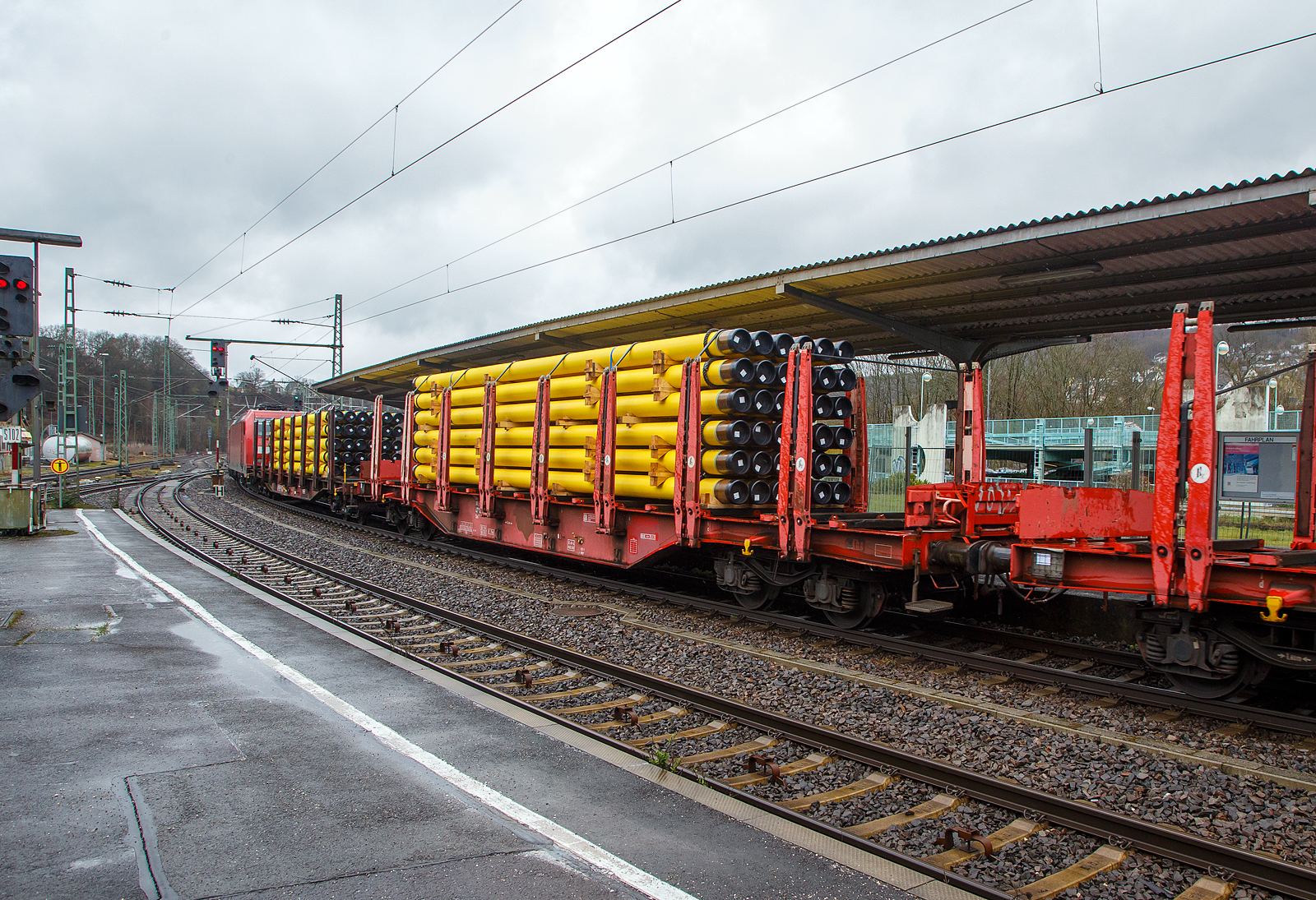 Vierachsiger Drehgestellflachwagen mit Rungen, Stirnwandklappen und Niederbindeeinrichtung, 81 80 4712 097-2 D-DB, der Gattung Sns 727, der DB Cargo AG am 01.04.2023 im Zugverband bei einer Zugdurchfahrt im Bahnhof Betzdorf (Sieg). Hier beladen mit 36 gelb beschichteten Gasrohren bzw. HFI-längsnahtgeschweißte Stahlrohre Ø 323.9 x 12,7 (DN/NW 300 mm bzw. 12 ¾ Inch) mit gelber MAPEC® Polyethylen (HDPE)-Umhüllung), in Herstellungslänge vom 12 m. Das Metergewicht der Rohre beträgt 97,5 kg/m (ohne Umhüllung), so ist der Wagen mit ca. 45 t beladen. Der Hersteller der Stahlrohre ist die Mannesmann Line Pipe GmbH in Siegen (ex RW Fuchs), gehört zum Salzgitter-Konzern.

In den Jahren 2001 und 2002 beschafft die DB AG vierachsige Flachwagen mit festen Rungenpaaren und niedrigen, umlegbaren Stirnborden, die mit je zwei kurzen Fallrungen gesichert werden. Die bei Grennbrier Europe Wagony Swidnica gebauten (dieser 2002) und als Sns 727 eingereihten Wagen, gleichen in vielen Komponenten den parallel beschafften Rbns 646, sind jedoch 5,91 m kürzer. Durch die reduzierte Länge und den kleineren Kurvenüberhang ließ sich die Wagenbreite um 330 mm gegenüber dem Rbns 646 vergrößern, und die Ladebreite von 2,52 m auf 2,85 m.

Wagenboden ist mit begehbaren (und nicht befahrbaren) Gitterrosten vollständig abgedeckt, die 15 hölzernen Ladeschwellen sind fest. An jeder Wagenseite befinden sich acht, innen mit Schichtholzleisten versehene Festrungenpaare, die im entlasteten Zustand oben 20 mm zur Fahrzeugmitte geneigt sind. Die in den Rungen integrierten Spannvorrichtungen verfügen über so lange Gurte, dass auch eine das G2-Profil ausnutzende Ladung gesichert werden kann. Der Sns 727 ist vorzugsweise für die Beförderung von Rohren, sowie den Transport von schweren Stahlerzeugnissen vorgesehen und überwiegend in festen Relationen im Einsatz.

TECHNISCHE DATEN:
Gattung: Sns 727
Spurweite: 1.435 mm (Normalspur)
Länge über Puffer: 20.440 mm
Drehzapfenabstand: 14.140 mm
Radsatzstand in den Drehgestellen: 1.800 mm
Ladelänge: 19.098 mm
Ladebreite: max. 2.850 mm (zwischen den Rungen)
Ladefläche: 54,4 m²
Fußbodenhöhe über SO: 1.350 mm (OK Ladeschwelle)
Rungenhöhe: 2.000 mm
Eigengewicht: ca. 26.500 kg 
Zuladung bei Lastgrenze S: 63,5 t (ab Streckenklasse D); DB Netz CM 57,5
Max. Geschwindigkeit: 100 km/h / 120 km/h (leer)
Kleinster Gleisbogenhalbmesser:	 75 m
Bauart der Bremse: KE-GP-A (LL)
Bremssohle: IB 116
Verwendungsfähigkeit: nein
