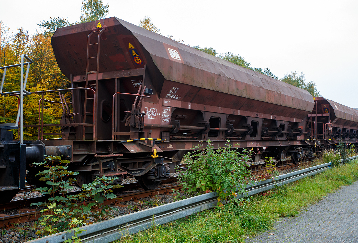 Vierachsiger offener Drehgestell-Schüttgutwagen mit dosierbarer Schwerkraftentladung, 31 80 6940 387 D-DB, Gattung Facs 124 (ex DR Gattung Eads-y), der DB Cargo AG, steht 12 Oktober 2025, eingereiht in einen Schotterzug, im Bahnhof Herdorf.

Der Wagen wurde 1979 ANF Industrie in Frankreich für die DR – Deutsche Reichbahn gebaut und geliefert. 

Die DR ließ zwischen 1978 und 1980 bei der französischen Firma Ateliers de construction du Nord de la France, abgekürzt ANF Industrie, auch bekannt unter Markenname „Blanc-Misseron“, über 1.450 vierachsige offene Selbstentladewagen mit vier Kammern bauen, die zunächst als Eads-y (5970) eingereiht werden. Bei der DB AG wurden die Wagen 1994 in Facs 124 umgezeichnet. Die ANF Industrie mit Sitz in der französischen Kleinstadt Crespin im Département Nord (an der Grenze zu Belgien), wurde 1990 von Bombardier Transportation übernommen, 2021 übernahm dann Alstom das Werk von Bombardier Transportation.

Bei den offenen Selbstentladewagen hat der Laderaum die Form mehrerer nebeneinanderstehender (4) Trichter. Der Entladevorgang erfolgt über die Schwerkraft des Ladegutes. Mehrere Auslauföffnungen mit Drehschiebern (4 pro Längsseite) ermöglichen die restlose Entladung des Wagens nach der einen oder anderen Seite. Die Menge ist regulierbar - so wie es zum Beispiel für die Entladung über Förderband erforderlich ist. Geeignet sind die Wagen für den Transport nicht nässeempfindlicher Güter in loser Schüttung. Die Drehschieber über einer Einrichtung auf der Bühne an einer Stirnseite des Wagens können einzeln bedient werden.

Der Wagen ist für den Transport von Nässe unempfindlichen Schüttgütern vorgesehen. Das Untergestell besteht aus miteinander verschweißten Blechen und Walzprofilen. Der Wagenkasten ist eine Schweißkonstruktion und besteht aus vier Trichtern. Querrippen teilen den Wagenkasten in vier Räume, von denen jeder an seinem Unterteil zwei Entladeöffnungen aufweist, die sich an beiden Seiten der horizontalen Mittellinie des Wagens befinden. Über jeder Entladeöffnung ist am Kastenblech eine Stütze für einen Vibrator angeschraubt.
Die acht kreisförmig ausgebildeten Wölbschieber sind auf Rollen gelagert und verschieben sich auf Laufbahnen, die außerhalb der Rinnen angebracht sind. Unter jeder Entladeöffnung sind eine feste und eine schwenkbare Auslaufrutsche angeordnet. Die schwenkbaren Auslaufrutschen werden einzeln durch einen Hebel betätigt, der in der Nähe der Rutsche angebracht ist. Die Betätigung der Wölbschieber erfolgt von der Bedienungsplattform aus. Die Entladung des Wagens erfolgt nach Öffnen der Schieber durch die Schwerkraft des Ladegutes. Für den Zugang zur Bedienungsplattform sind zwei Auftritte mit Gitterrosten (500 x 160 mm) vorhanden. Die Menge ist regulierbar - so wie es zum Beispiel beim Einschottern erforderlich ist.

Das Entfernen von Ladegutresten in der Be- oder Entladestraße ist nur durch leichte Gummihammerschläge auf die äußeren Behälterwandungen gestattet oder durch den Einsatz von Pressluftlanzen im Laderaum!

TECHNISCHE DATEN:
Hersteller: ANF Industrie (Frankreich)
Spurweite: 1.435 mm (Normalspur)
Achsanzahl: 4 (in 2 Drehgestellen)
Länge über Puffer: 19.040 mm
Drehzapfenabstand: 14.000 mm
Achsabstand im Drehgestell: 1.800 mm
Laufraddurchmesser: 920 mm (neu)
Größe der Beladeöffnung: 1.800 x 15.300 mm
Laderaum:  70 m³
Breite der festen Auslaufrutschen: 600 mm
Breite der schwenkbaren Auslaufrutschen: 476 mm
Wagenhöhe:  4.000 mm
Höchstgeschwindigkeit: 100 km/h (beladen) / 120 km/h (leer)
Maximales Ladegewicht: 55,0 t (ab Streckenklasse C)
Eigengewicht: 25.000 kg
Drehgestell-Bauart: Y 25 Cs – 639
Kleinster bef. Gleisbogenradius: 75 m
Bauart der Bremse:  KE-GP (LL)
Bremssohle: IB 116
Intern. Verwendungsfähigkeit: RIV
