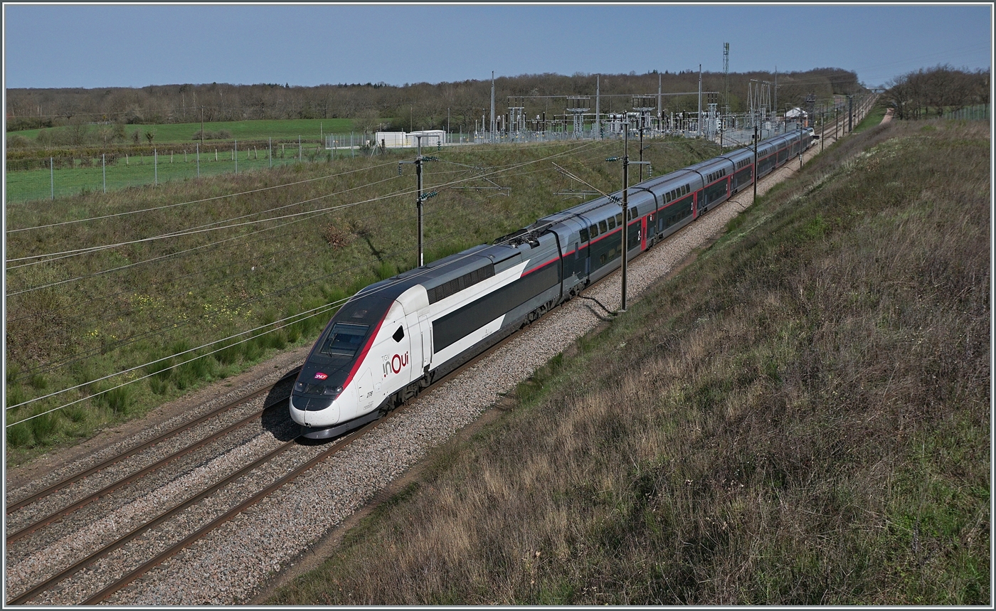 Voilà, der SNCF TGV Rame 278 ist als SNCF iNOUi TGV 6937 von Paris Gare de Lyon (ab 09:46) nach Annecy (an 13.28) auf der Schnellfahrstrecken Paris - Lyon bei Saint Émiland in voller Fahrt unterwegs unterwegs. 
Soweit der eigentliche Bildtext. Schon seit längerem reizt mich die Fotografie schneller Züge. Seit die FS Trenitalia ETR nach Paris fahren rückte die TGV Strecken Paris - Lyon ganz besonders in den Fokus. Doch man geht nicht eben hin, wartet und drück ab. Es brauchte eine länger Vorbereitung. Allein die Kalkulation, WANN der Zug vorbeifährt ist nicht ganz einfach, gelang mit aber auf gut 6 Minuten Genauigkeit. Die Fotostelle auch nicht einfach eine geeignete zu finden, diese hier war  Plan B , nachdem ich die ursprüngliche nicht auf Anhieb fand. Dann die lange Anfahrt! Da wir eine Autobahnausfahrt verpassten, schmolz die üppige kalkulierte Zeit wie Schnee im Sommer und wenige Minuten nach der Ankunft kam auch schon der ETR 400; es waren also echt spannende Fotomoment zum Ferienanfang, bei immerhin perfekt passendem Wetter.
Übrigens, das  Wissen , das dieses Bild den TGV Paris- Annecy zeigt, passiert auf der Tatsache dass dieser Zug 17 Minuten nach dem ETR 400 in Pairs abfährt, da die Strecke sehr stark befahren ist, bin ich noch dabei, die andern Züge auszurechnen, was durch die gegebenen Unbekannte Abfahrt und Bestimmungsstation doch nicht ganz so einfach ist. 
6. April 2024
