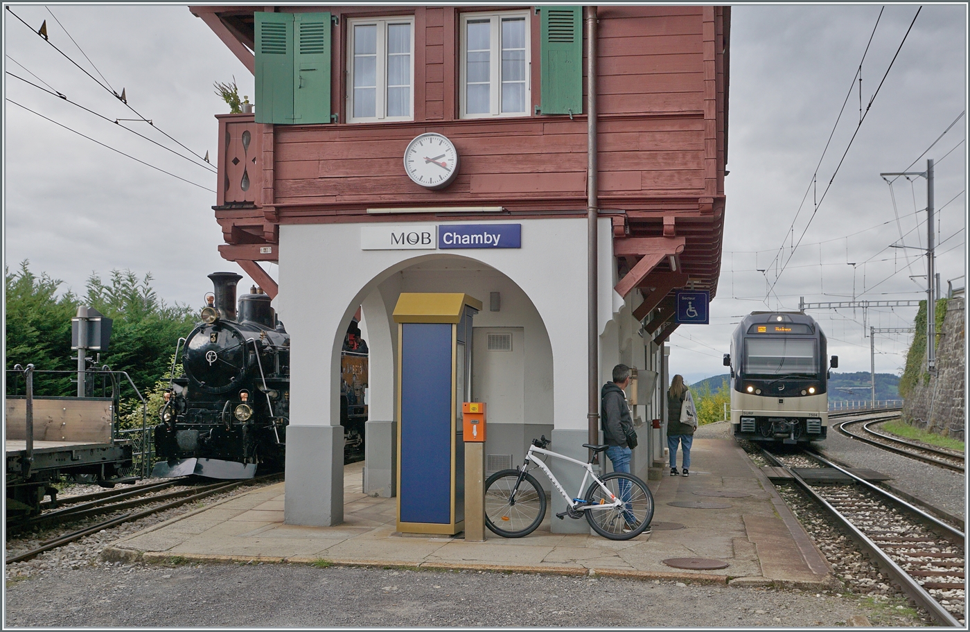 Während in Chamby der CEV MVR ABeh 2/6 7504  Vevey  als R34 nach Montreux einfährt, versteckt sich hinter dem schön hergerichteten Empfangsgebäude auf Gleis 3 die HG 2/4 N° 3 der Blonay Chamby Bahn.

4. Oktober 2025