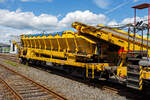 Plasser & Theurer Material-, Förder- und Siloeinheiten MFS 38 (teilweise auch BSW 2000 - Bunker-Schüttgut-Wagen genannt) der HERING Bahnbau, Burbach, Nr. 4, Schweres Nebenfahrzeug Nr. D-HGUI 99 80 9552 122-0, ex 97 19 22 551 17-3, ist am 07.07.2024 auf dem Betriebshof der Westerwaldbahn (WEBA) auf der Bindweide bei Steinebach/Sieg abgestellt.

Diese MFS 38 wurde 1993 von Plasser & Theurer unter der Fabriknummer 2158 gebaut, wobei als Fahrgestell ein vierachsiger ehemaliger Drehgestell-Flachwagen der Gattung Rs 680 (ex SSlmas 53), der 1962 von M.A.N. im Werk Nürnberg unter der Fabriknummer 146718 gebaut wurde, Verwendung fand. Diese Wagen wurden Plasser & Theurer vom Kunden beigestellt. Bei einem Drehgestell konnte ich als Hersteller LHB (Linke-Hofmann-Busch, Salzgitter) ausmachen (Baujahr 1965, Fabriknummer 3109).

TECHNISCHE DATEN:
Maschinenart: Material-Förder-Siloeinheit MSF 38
Hersteller: Plasser & Theurer
Spurweite: 1.435 mm (Normalspur)
Anzahl der Achsen: 4 (in 2 Drehgestellen)
Länge über Puffer:19.900 mm
Gesamtlänge mit Übergabeband: 23.550 mm
Drehzapfenabstand: 13.000 mm
Achsabstand im Drehgestell: 2.000 mm
Laufraddurchmesser: 1.000 mm (neu)
Drehgestell-Bauart: Minden Dorstfeld-Drehgestell 931 / 932
Breite: 2.890 mm
Höhe: 4.280 mm
Eigengewicht: 38 t
Max. Zuladung (Nutzlast): 42 t
Ladevolumen: 38 m³
Höchstgeschwindigkeit: 100 km/h (geschleppt)
Kleister befahrbarer Gleisbogen: R=120 m (angeschrieben)
Bremse: KE – GP
Motor: luftgekühlter Deutz Dieselmotor vom Typ F6L 912 F
Leistung: 82 kW
Dieseltankvolumen: 750 l
Übergabeband: +/- 45 Grad schwenkbar.
Entladezeit: 3,5 Minuten
Entladeabstand von Gleismitte: max. 4,5 m
Die Förderbänder sind in folgenden Geschwindigkeiten regelbar:
Siloband: 1. Gang (Speichern)   0 - 0,028 m/s / 2. Gang (Durchfördern)  0 - 0,140 m/s
Übergabeband: 0 - 1,000 m/s

Einsatz und Arbeitsweise:
Bei diesem MFS 38 (ohne nachfolgendes „D“) ist das Übergabeband beidseitig zum Gleis um 45 Grad schwenkbar, so ist ein  Entladen nebens Gleis oder zum Nachbargleis möglich. Die MSF 38 haben ein Fassungsvermögen 38 m³ bzw. eine Nutzlast von 42t, bei einem Eigengewicht von 38t. Die Förderbänder werden hydraulisch angetrieben. Der Antrieb des Hydraulikaggregates erfolgt durch einen luftgekühlten Deutz Dieselmotor vom Typ F6L 912 mit einer Leistung von 82 kW.

Mit den Materialförder- und Siloeinheiten können unterschiedliche Schüttgüter wie beispielsweise Abraum, Planum- und Frostschutzmittel oder Bettungsstoffe unkompliziert, geladen, gefördert, gespeichert und entladen werden. Das Abraumverladesystem ist weitestgehend automatisiert und benötigt zur Bedienung nur wenig Personal. Das System verfügt zudem über eine autarke Energieversorgung (durch Dieselmotore). Ein unabhängiges Entladen ist durch schwenkbare Übergabebänder an jeder geeigneten Stelle möglich. Die MFS-Wagen können in Kombination mit einer Beladestation in beliebiger Anzahl aufgereiht und vor Kopf be- und entladen werden.

Am Boden jedes MFS 38 befindet sich ein über die ganze Wagenbreite gehender Fördergurt und an der Stirnseite ein breites Abgabeförderband. Das Aushubmaterial fällt von der Maschine kommend auf den Bodengurt, wird zum Abgabeförderband gebracht und an die nächste Einheit übergeben. Dieser Vorgang wiederholt sich, bis die am weitesten entfernte Siloeinheit erreicht wird. Bei dieser hintersten Siloeinheit ist das Abgabeförderband an der Stirnseite des Wagens in Ruhestellung. Auch der Fördergurt am Boden des Wagens ist so lange in Ruhestellung, bis die obere Füllgrenze erreicht ist. Dann wird der Fördergurt in Bewegung versetzt und dadurch im Übergabebereich freier Raum für die weitere Beladung geschaffen. Durch die dem Fülltempo angepasste Geschwindigkeit des Fördergurts wird die ganze Siloeinheit vollständig gefüllt. Das Fassungsvermögen einer Siloeinheit beträgt 38 Kubikmeter.

Nach Füllung einer Teilgruppe des Abraumzuges kann diese von der Restgruppe abgekuppelt werden, zu einer Entladestelle gefahren und dort entleert werden, während die Restgruppe des Abraumzuges noch befüllt wird. Das Entladeband ist nach beiden Seiten ausschwenkbar. Die Entladung kann dabei auf einer Deponie erfolgen oder es können LKW's oder Waggons am Nachbargleis beladen werden. Die MFS 38 (ohne nachfolgendes „D“) des Abraumzuges können durch Ausschwenken aller Abgabeförderbänder gleichzeitig entleert werden. Die Entladung eines Wagens dauert ungefähr 3,5 Minuten.