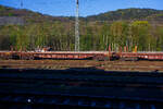 Vierachsiger Drehgestellflachwagen (Schwellentransportwagen) mit Stirnwandrungen und Ladeger�st, 82 80 4713 083-2 D-DB, der Gattung Slnps 468, der DB Cargo Deutschland AG abgestellt am 23 April 2026 im Rbf Wetzlar. Aufnahme aus einem Zug heraus.

Der Schwellentransportwagen dient beim Gleisneu- und Gleisumbau dem Transport von Schwellen f�r Schienenumbauz�ge nach dem Umbauverfahren SUM. Seitlich angebrachte Portalkranschienen und �berfahrschienen zwischen benachbarten Schwellentransportwagen erm�glichen die Befahrbarkeit mit Portalkr�nen.

Die Wagen der Bauart Slnps 468 sind aus der Bauart Snps 719 entstanden und entsprechen in der Untergestellkonstruktion, in der Zug-/Sto�einrichtung, Bremse und Drehgestell der Ursprungsbauart. Die Rungen, Rungenhalter, Niederbindeeinrichtung und Ladeschwellen wurden f�r den Aufbau eines Ladeger�stes entfernt. Die Wagen dienen vorrangig zum Schwellentransport beim Umbauverfahren SUM und sind mit Portalkranschienen der Spurweite 2806 mm und �berfahrschienen ausger�stet.

Bei Portalkranbetrieb mit eingelegten �berfahrschienen betr�gt der kleinste befahrbare Gleisbogenhalbmesser 190 m. Zum Transport der Schwellen sind die Wagen mit einem Ladeger�st aus L�ngs- und Quertr�gern sowie mit stirnseitigen St�tzen/Rungen versehen, dessen Abmessung auf die verwendeten Portalkr�ne abgestimmt ist. Die Wagen k�nnen sechs 30er Betonschwellenpakete bzw. 180 Schwellen aufnehmen. F�r die Auflage der Schwellen besitzt das Ger�st rutschhemmende Holzbohlen. Zur Verzurrung der Schwellen sind 12 Gurtwinden incl. Spanngurt mit gegen�berliegenden Spannhaken l�ngsseitig am Wagen angebracht. Der Wagenboden ist mit einem begehbaren Gitterrosten vollst�ndig abgedeckt. 