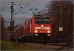 Bei Einbruch der Dunkelheit fährt der RE nach Basel mit der Schwarzwaldbahnlok 146 238 bei Bamblach vorüber.