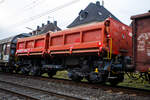 Vierachsiger zweimuldiger Drehgestell-Schüttgutkippwagen mit elektrohydraulischer Betätigung, 31 80 6770 466-4 D-DB, der Gattung Fans 128.2, der DB Cargo Deutschland AG, am 14 November 2025 im Zugverband bei einer Zugdurchfahrt in Kirchen/Sieg.

Der zweimuldige Drehgestell-Schüttgutkippwagen (Zweiseiten-Kastenkipper) ist für den Transport von feuchtigkeitsunempfindlichen Schüttgütern wie z.B. Splitt, Kies, Schotter, erdfeuchtem Sand, Bodenaushub oder Bauschutt vorgesehen. Der Wagen besitzt einen elektrohydraulischen Kippantrieb und eine speicherprogrammierbare Steuerung (SPS). Entwickelt und in Serie gebaut wurde der Kastenkipper vom FEW Fahrzeug- und Entwicklungswerk Blankenburg (Harz) der DB AG. Die Drehgestelle liefert das Werk Halle, die Wagenkästen fertigen das Werk Kaiserlautern und DWA Niesky.

Für den Einsatz als Einzelwagen, in Wagengruppen oder beim Massenschüttgut-Transport in Ganzzügen besitzt er eine autarke Wagentechnik, die eine von äußeren Energiequellen unabhängige Entladung ermöglicht. Das Schüttgut kann als Nah- oder Weitablage abgegeben werden. Das Schüttgut nach beiden Längsseiten gekippt werden. Der Wagen verfügt über zwei getrennt kippbare Mulden. Die Wagen haben eine Batterie die über Achsgeneratoren (hier im Bild am rechten Drehgestell) aufgeladen werden.

TENISCHE DATEN:
Erstes Lieferjahr: 1996
Spurweite: 1.435 mm (Normalspur)
Länge über Puffer: 11.600 mm
Drehzapfenabstand: 6.580 mm
Achsabstand im Drehgestell: 1.800 mm
Drehgestell-Bauart: Y 25 Lsd 1 - 629
Laufraddurchmesser: 920 mm (neu)
Laderaum: 2 x 18,0 m³
Ladefläche: 2 × 12,0 m²
Höhe der Beladeöffnung: 3.512 mm
Kippwinkel des Kastens: 45°
Kippantrieb Energieversorgung: autark, über Batterie geladen über Achsgenerator
Kippantrieb Kapazitätsverbrauch pro Entladung: 5 bis 10 (Ah)
Kippbewegungen: über zwei Hydraulikzylinder je Kasten
Höchstgeschwindigkeit: 120 km/h (leer) / 100 km/h (beladen)
Eigengewicht: 29.500 kg
Maximales Ladegewicht: 60,5 t (ab Streckenklasse D4), oder DB CM4 54,5 t
Kleinster bef. Gleisbogenradius: 75 m
Bremse: KE-GP-A (LL)
Bremssohle: IP 116
Intern. Verwendungsfähigkeit: RIV

Der Wagen ist zum Transport von witterungsunempfindlichem Schüttgut (mit einer max. Kantenlänge von 40 cm). Der Aufbau besteht aus zwei einzeln kippbaren Kästen mit einem Fassungsvermögen von je 18 m³, die wahlweise nach rechts oder links gekippt werden können. Dabei besteht die Möglichkeit, die Abwurfweite in zwei Stufen zu variieren; „nah“ für die Tiefbunkerentleerung und „weit“ für das ebenerdige Abkippen. Für die Bedienung des Wagens befinden sich an den Stirnwänden zwei diagonal angeordnete Bedientableaus. Der gesamte Kippvorgang erfolgt nach Vorwahl der gewünschten Funktion vollautomatisch. Die entsprechenden Magnetventile werden dabei elektrisch angesteuert. Bei Ausfall des elektrohydraulischen Kippantriebes (z.B. entladene Batterie) können mittels Handpumpe und Betätigung der Handnotbetätigung an der entsprechenden Wegeventilgruppe die Hydraulikzylinder bewegt werden. Eine detaillierte Anweisung für das Vorgehen bei Ausfall ist in jedem Wagen im Batteriekasten deponiert.
