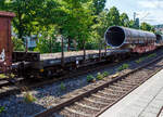 Vierachsiger Drehgestell-Flachwagen mit Drehrungen und Stirnwandklappen, jedoch ohne Seitenborde, 31 80 3961 632-7 D-DB, der Gattung Rmms 664, der DB Cargo AG, eingereiht in einen gemischten G�terzug bei der Durchfahrt im Bahnhof Kirchen (Sieg) am 16 Juli 2026. Der Wagen ist hier als Schutz- und Kuppelwagen vor dem Wagen der Gattung Samms 489 (31 80 4852 858-8 D-DB) eingereiht.

Ab 1968 lie� die DB 1.760 Rmms 664 bauen, dieser wurde 1973 von der Waggon Union in Berlin gebaut.

Mit einer Ladel�nge von 12,80 m dienen diese Wagen mit aufgeklappten Ladeschwellen zur Bef�rderung von schweren langen Erzeugnissen der Eisen- und Stahlindustrie (wie Walzprofile) und anderen sperrigen und schweren G�tern. Mit eingeklappten Ladeschwellen, also mit ebener Ladefl�che, eignet er sich auch f�r die Bef�rderung von schweren Kettenfahrzeugen. Vor den umlegbaren Stirnw�nden sind je zwei absenkbare Rungen angeordnet. Der Wagen kann mit umgelegten Stirnw�nden und abgesenkten Rungen gefahren werden. Die H�he der umgelegten Stirnw�nde �ber FO betr�gt 38 mm. An den L�ngsseiten hat der Wagen je 6 Drehrungen. Der Fu�boden besteht aus Kiefernbohlen mit den Abmessungen 70 x 180 mm. Er kann eine Radlast von 5,0 t aufnehmen. Im Fu�boden sind 6 geteilte, klappbare Ladeschwellen eingebaut.

Die an den Stirnseiten angeordneten �berfahrklappen gestatten abgeklappt das Durchfahren von Gleisb�gen mit mindestens 150 m Halbmesser. Die �berfahrklappen liegen im abgeklappten Zustand auf 4 Konsolen auf. In senkrechter Stellung werden sie durch je 2 am Kopfst�ck angeordneten Fallrungen gehalten.

Die Wagen haben eine Klotzbremse mit stufenlos, selbstt�tiger Lastabbremsung. Die Bremskraft nach dem minder belasteten Drehgestell gesteuert. Das Steuerventil ist im Wagenuntergestell angeordnet.

TECHNISCHE DATEN:
Spurweite: 1.435 mm (Normalspur)
Gattung/Bauart: Rmms 664
Erstes Baujahr: 1968
Anzahl der Achsen: 4 in 2 Drehgestellen
L�nge �ber Puffer: 14.040 mm
Drehzapfenabstand: 9.000 mm
Achsabstand im Drehgestell: 1.800 mm
Ladel�nge: 12.644 mm
Ladebreite: 2.904 mm
Ladefl�che: 36,0 m�
Fu�bodenh�he �ber SO: 1.235 mm
H�chstgeschwindigkeit: 100 km/h (beladen) / 120 km/h (leer)
Eigengewicht: 21.000 kg 
Maximale Ladegewicht: 59,0 t (ab Streckenklasse C)
Laufraddurchmesser (neu): 920 mm
Kleinster bef. Gleisbogenradius: 35 m
Bauart der Bremse: KE-GP-A max. 55 t (LL)
Bremssohle: IB 116 (C952-1)
Internationale Verwendungsf�higkeit: RIV

Die Bedeutung der Gattung Rmms:
R = Drehgestellflachwagen in Regelbauart
mm = Ladel�nge unter 15 m
s = zugelassen f�r Z�ge bis 100 km/h (beladen)
664 = Bauartnummer

