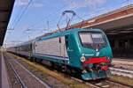 Lok E 464.557 wurde mit ihrem Zug auf einem Zwischengleis im Bahnhof von Verona Porta Nuova in Wartestellung abgestellt.