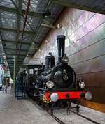 Die Dampflokomotive HSM 89  Nestor , spter NS № 1010 (NS-Baureihe 1000) am 24 Juni 2025 im Het Spoorwegmuseum (bis 2005 NSM - Nederlands Spoorwegmuseum / Niederlndischen Eisenbahnmuseum) in Utrecht im ehemaligen Bahnhof Maliebaan.   

Die Dampflok wurde 1879 von Borsig in Berlijn-Tegel unter der Fabriknummer 3730 gebaut und an die damalige HSM - Hollandsche IJzeren Spoorweg-Maatschappij (Hollndische Eisenbahn-Gesellschaft) geliefert, 1880 erfolgte die Inbetriebnahme.

HSM 89  Nestor  ist eine niederlndische 1B (2-4-0) Tenderlokomotive, die vom Niederlndischen Nationalbahnmuseum erhalten wurde. 29 seiner Art wurden fr den NS-Vorgnger Hollandsche IJzeren Spoorwegmaatschappij (HSM) gebaut.

In den frhen Tagen war die HSM die einzige Eisenbahngesellschaft in den Niederlanden, die ihren Lokomotiven immer einen Namen sowie eine Nummer gab. Der Nestor zum Beispiel wurde auch die Zahl 89 zugewiesen. Trotz der Tatsache, dass es immer als  Der Nestor  bezeichnet wurde, zeigt das Namensschild nur  Nestor . Diese Serie von Lokomotiven wurde  Tenners  genannt, weil sie mit Dampfdruck in Hhe von 10 Atmosphren umgehen konnten. Ein bemerkenswertes Merkmal dieser Lokomotivserie ist, dass der Fhrerstand der aus Holz und nicht aus Metall besteht. Ihre Lokfhrer und Heizer wurden daher manchmal  Woonwagenbewoners  genannt, was ungefhr  Caravan-Bewohner  bedeutet. Metallstangen, die als Schienenwchter bekannt sind, wurden an der Vorderseite der Rahmenplatten befestigt. Der Lokfhrer konnte Besen zu diesen Wachen montieren, um die Schienen unter verschneiten Bedingungen zu rumen. Wie alle Lokomotiven hat der Nestor auch Fetttpfe montiert. Diese Tpfe wren mit Fett und Garn gefllt oder gefhlt, um die Achsen zu schmieren.

HSM
Mit dem Ausbau einer Eisenbahnlinie und der Erffnung einer weiteren 1879 wurde die Notwendigkeit, ihre Sammlung von Lokomotiven zu erweitern, deutlich und bestellte 29 dieser Maschinen in Borsig. Sie waren 74-82, 89-98 und 116-125 nummeriert, weil die HSM Lokomotiven anhand des Empfangsauftrags nummerierte. Die Serie hie EOS - JORDAENS, die Namen von 74 und 125. Trotz der Namensschilder, die nur einen Namen haben, wurden sie in der Sprache immer als Der Name bezeichnet (z. B.  Der Nestor  statt  Nestor ).

Bei ihrer Ankunft erhielten verschiedene ltere Lokomotiven weniger wichtige Arbeiten, die noch ltere Lokomotiven aus dem Dienst zogen. Mit der Ankunft neuer Sharp Stewart-Lokomotiven im Jahr 1890 wurden die EOS - JORDAENS auf sekundre, weniger wichtige Aufgaben reduziert, wie sie es zuvor bei lteren Lokomotiven getan hatten. Sie arbeiteten in den Depots Almelo, Amsterdamer Hauptbahnhof, Apeldoorn, Haarlem und Zutphen und den meisten groen Stationen entlang einer Linie nach Osten nach Westen mitten im Land. Spter verteilten sie sich noch mehr auf andere HSM-Depots, die immer mehr auf Rangierarbeiten reduziert wurden.

NS
Bedingt durch den Ersten Weltkrieg wurde 1917 eine Zweckgemeinschaft der unabhngigen Eisenbahngesellschaften HSM beziehungsweise HIJSM (Hollandsche IJzeren Spoorweg-Maatschappij) und SS (Maatschappij tot Exploitatie van Staatsspoorwegen) gegrndet. Die beiden Gesellschaften errichteten einen gemeinsamen Bahnbetrieb, blieben aber rechtlich unabhngig. Dies nderte sich 1938, als HIJSM und SS vollstndig fusionierten und in der AG NS (Nederlandse Spoorwegen, frher Nederlandsche Spoorwegen geschrieben) aufgingen. Das Rollmaterial wurde bereits 1921 zusammengelegt, so wurden die EOS - JORDAENS zu NS 1001 - 1029 nummeriert. Die NS vergrerte auch die Fenster in der Kabine.

Bis 1923 befanden sich acht von ihnen am Hauptbahnhof Utrecht, der vor der Fusion ausschlielich Staatsspoorwegen-Gebiet war. Sie wurden ausschlielich zum Rangieren verwendet. In Amersfoort waren fnf weitere mit der gleichen Arbeit und in Winterswijk, vier, obwohl diese vier auch Zge zu einigen nahe gelegenen Bahnhfen fuhren. 1924 wurde jedoch die Mehrheit der NS-1000 in die westlichsten Depots, einschlielich Apeldoorn, verlegt.

Elf der Baureihe wurden 1921-1923 ausgemustert. Der NESTOR berlebte mit dem Rest bis 1934. In diesem Jahr schickte NS alle bis auf zwei, NS 1010 & 1011, auf den Schrottplatz. Ein Jahr spter folgte auch NS 1011. Obwohl der NESTOR (NS 1010) auch 1934 abgeschafft werden sollte, half die NVBS (Niederlndische Vereinigung der Interessenten in der Eisenbahn- und Straenbahnindustrie) dabei, sie fr das noch zu bauende niederlndische Eisenbahnmuseum zu erhalten, so dass sie in Boxtel gelagert wurde.

Die Lokomotive wurde zusammen mit anderen fr das Museum reservierten Rollmaterial ein paar Mal whrend des Zweiten Weltkriegs bewegt. 1944 war die NESTOR in Maastricht, dort wurde sie den zurckweichenden Deutschen schwer beschdigt (gesprengt). Als der Krieg endete, wurde die Maschine eine Weile in Almelo gelagert, immer noch schwer beschdigt. Erst 1953 erteilte die NS die Erlaubnis, sie zu reparieren. Die Reparatur wurde 1964 abgeschlossen. In diesem Jahr fuhr die Lokomotive die letzten 100 Meter alleine zum niederlndischen Eisenbahnmuseum, obwohl die ntige Energie mit Druckluft aus einem Diesel geliefert wurde.

Der NESTOR war die letzte NS-Lokomotive, die fr Museen restauriert wurde. Sie bekam ihren Look aus den 1880er Jahren, einschlielich der Holzkabine mit hohen Fenstern.

Im niederlndischen Eisenbahnmuseum ist NESTOR nicht der einzige Ex-NS 1010. Die Baunummer der Baureihe 1000 wurde spter fr Elektrolokomotiven verwendet, deren Zehnter ebenfalls erhalten blieb.

TECHNISCHE DATEN:
Typ: Schnelldampflok 
HSM-Serie: EOS - JORDAENS, ab 1921 NS 1001 - 1029
Spurweite: 1.435 mm (Normalspur)
Achsfolge: 1B (engl. 2-4-0)
Lnge ber Puffer: 14.160 mm (Lok 8.260 mm + Tender 5.900 mm)
Treibraddurchmesser: 1.860 mm (neu)
Hchstgeschwindigkeit: 90 km/h
Gesamtheizflche: 93,5 m
max. Dampfdruck: 10,3 kg/cm
Anzahl der Zylinder: 2 ( 406 mm x 558 mm Hub)
Eigengewicht: Lok 38,8 und Tender 25,1 t = 63,9 t
Anhngelast: 3560 kg
Wasservorrat: 9 m
Kohlevorrat: 3,6 t
