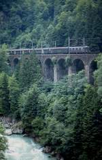 Eine Re 4/4 I ist im Mai 1980 auf der Gotthard-Nordrampe bei Gurtnellen mit einem Regionalzug unterwegs