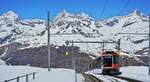 Hinab nach Zermatt fährt am 10.05.2024 ein Bhe 4/6-Doppel der Gornergratbahn, zweites Fahrzeug ist der Beh 4/6 3093, aus der Station Rotenboden, im Hintergrund die Spitzen der drei Viertausender Dent Blanche (4357 m), Obergabelhorn (4073 m) und Zinalrothorn (4221 m)